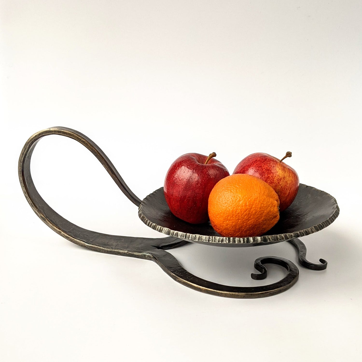 Hand forged dish on a decorative stand.