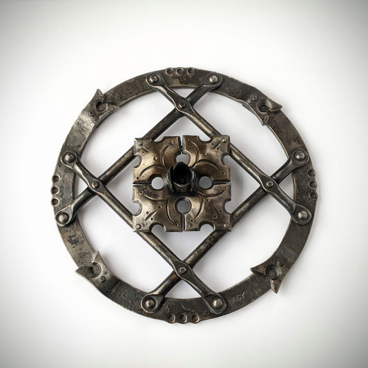 Hand forged wall art combining a flower, a grid of bars, set in a ring.